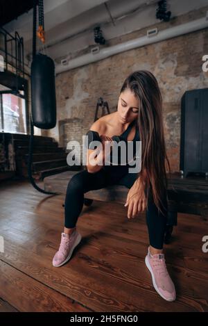 Junge Frau pumpt die Muskeln mit einem Arm Hantel heben. Stockfoto