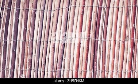 Wässern Zaun von trockenen Zweigen als Hintergrund. Traditioneller rustikaler Zaun. Abstrakter Holzhintergrund. Stockfoto