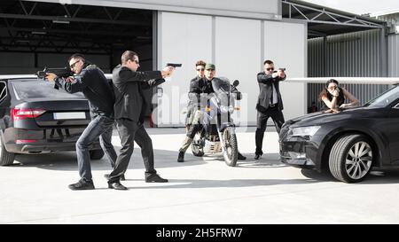 Taktisches Training. Ein bewaffnetes Sicherheitsteam schützt eine prominente vip-Person, die sich in einer gefährlichen Kampfsituation befindet, wenn sie angegriffen wird. Sicherheitspolizei Stockfoto