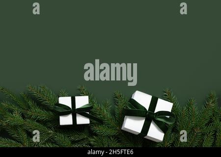 Weihnachtlich grüner Hintergrund mit Tannenzweigen und Geschenkschachteln. Weihnachtliche Grenze. Festliche Grußkarte mit Platz für Text. Blick von oben. Stockfoto