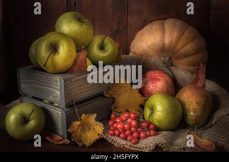 Äpfel und andere Lebensmittel auf dunklem Holzhintergrund im rustikalen Stil Stockfoto
