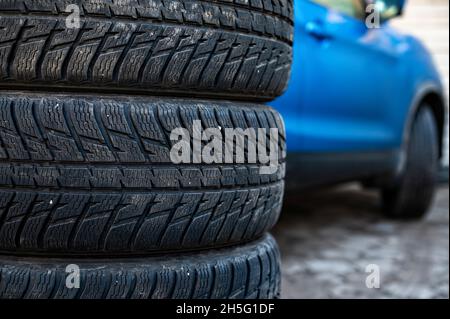 Winterreifen neben dem Auto im Radservice, saisonales Reifenwechselkonzept, Nahaufnahme Stockfoto