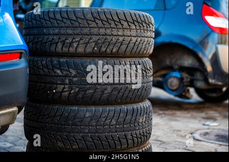 Winterreifen neben dem Auto im Radservice, saisonales Reifenwechselkonzept, Nahaufnahme Stockfoto