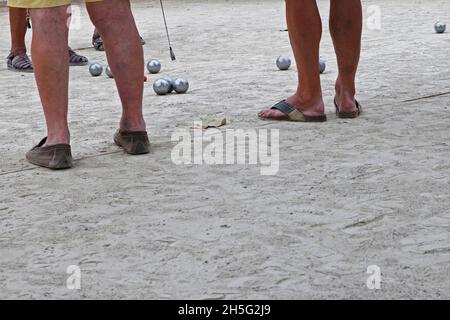 Franzosen, die gerade -auf einem öffentlichen Platz- Boule spielen. Keine Erkennbarkeit, da nur Beine. Cannes, Frankreich. Stockfoto