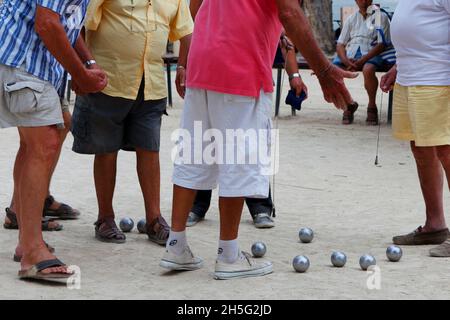 Franzosen, die gerade -auf einem öffentlichen Platz- Boule spielen. Keine Erkennbarkeit, da nur Beine. Cannes, Frankreich. Stockfoto