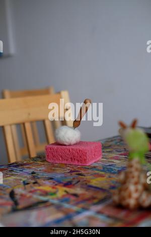 Nadel in einem gefilzten Würfel auf einem rosa Schwamm. Zubehör für Nadelfilz, Weben von Wolle handgefertigte Handwerk von Schafhaar. . Hochwertige Fotos Stockfoto