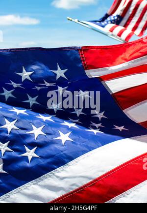 Nahaufnahme des Details der gestickten amerikanischen Flagge mit einem anderen auf Unscharf im Hintergrund vor blauem Himmel Stockfoto