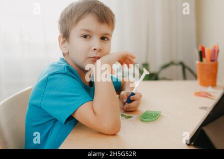 Nahaufnahme eines kleinen Jungen, der ein Diamantmosaik erstellt Stockfoto