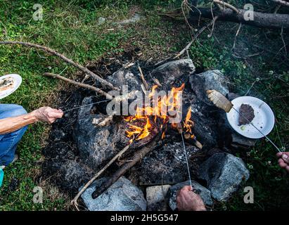 Gebratener Speck auf Lagerfeuer Flamme im Garten. Stockfoto