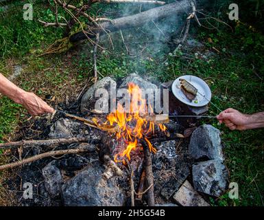 Gebratener Speck auf Lagerfeuer Flamme im Garten. Stockfoto