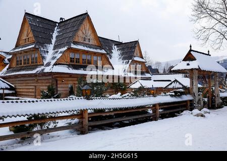 Zakopane, Polen - 21. März 2018: Ein großes Holzhaus mit einem traditionellen schrägen Dach, das mit Holzschindeln bedeckt ist. Es ist hier während sichtbar Stockfoto