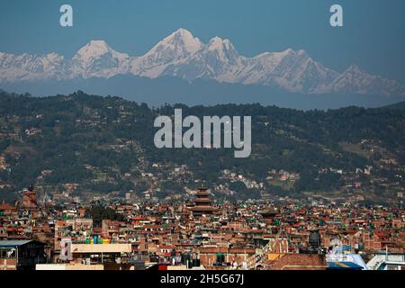 Bhaktapur, Bagmati, Nepal. November 2021. Nepals höchster Nyatapola-Tempel vom Bhaktapur der Durbar-Platz ist am Dienstagnachmittag von einer Bergstation am Stadtrand des Bhaktapur-Bezirks aus gegen die Langtang-Himalaya-Bergkette abgebildet. Mit erhöhter Sicht nach einigen Tagen des Abfalls im AQI, wird der Himmel des Kathmandu-Tals wieder von Dunst befreit, der aufgrund verschiedener menschlicher Aktivitäten entzündet wurde. Quelle: Amit Machamasi/ZUMA Wire/Alamy Live News Stockfoto