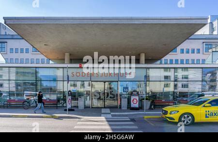 Stockholm, Schweden - 15. April 2021: Haupteingang zu einem der größten Krankenhäuser in Stockholm mit Besuchern und Taxi Stockfoto