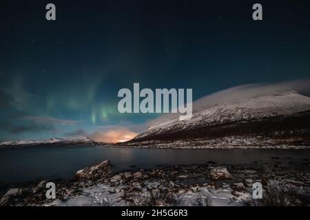 Borealis aurora fegt bei einer wolkenlosen Nacht über einen großen See in Kilpisjarvi, Lappland, Finnland. aurora polaris tanzt in Grün über den Himmel. Scandin Stockfoto