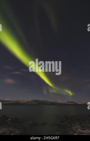 Borealis aurora fegt bei einer wolkenlosen Nacht über einen großen See in Kilpisjarvi, Lappland, Finnland. aurora polaris tanzt in Grün über den Himmel. Scandin Stockfoto