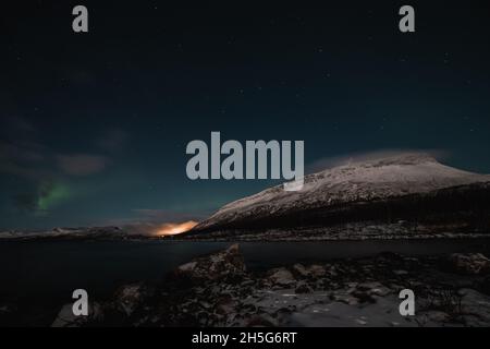 Borealis aurora fegt bei einer wolkenlosen Nacht über einen großen See in Kilpisjarvi, Lappland, Finnland. aurora polaris tanzt in Grün über den Himmel. Scandin Stockfoto