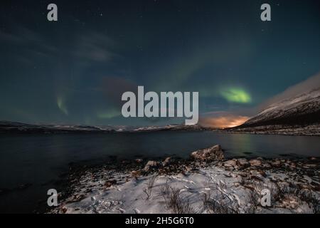 Borealis aurora fegt bei einer wolkenlosen Nacht über einen großen See in Kilpisjarvi, Lappland, Finnland. aurora polaris tanzt in Grün über den Himmel. Scandin Stockfoto