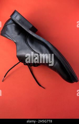 Nahaufnahme von einigen schicken schwarzen hellen Schuhen auf einer roten Oberfläche Stockfoto