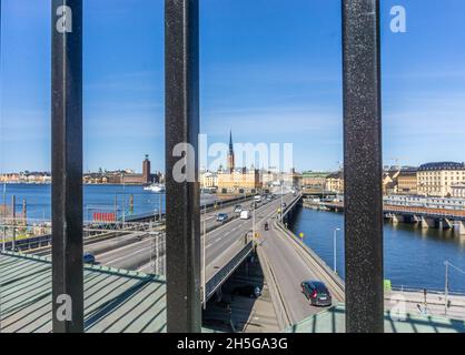 Stockholm, Schweden - 15. April 2021: Blick durch den Eisenzaun über den Brücken von einer Insel zur Altstadt im Zentrum von Stockholm Stockfoto