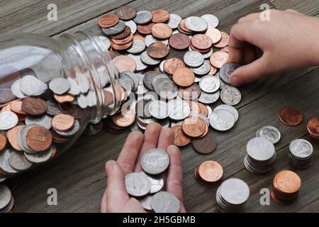 Kind zählt Münzen aus einem Glas Stockfoto