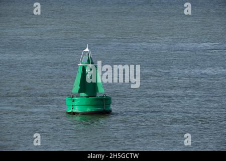 Grüne Boje auf dem Fluss in Rotterdam, Niederlande für die Sicherheit und Sicherheit der Boote, die auf dem Wasser unterwegs sind Stockfoto