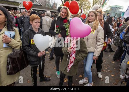 Familie mit Ballons und roten Rosen auf dem Malieveld, versammeln sich auf dem Malieveld vor einem protestmarsch durch Den Haag, um neue Regierungskovid-19-Maßnahmen anzuprangern.die Polizei schätzt, dass 20,000 Demonstranten bei einem demonstrationsmarsch wegen der neuen Anti-Korona-Maßnahmen auf die Straßen von Den Haag gegangen sind. Die Demonstranten lehnen die Verwendung von Impfbescheinigungen und QR-Codes ab, die ihrer Meinung nach die Gesellschaft Spalten, anstatt sie miteinander zu verbinden, einige Leute zweifeln auch an der Schwere oder Gültigkeit der Pandemie, zahlreiche Publikationen wurden genutzt, um ihre Überzeugungen wieder durchzusetzen. Stockfoto