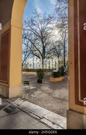 München: Der verlassene Hofgarten an einem sonnigen Spätherbsttag. Ein Stuhl, der in der Sonne steht. Stockfoto