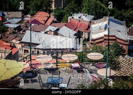 Blick auf das Boho Patio Cafe über den Dächern der flippigen Altstadt Tiflis Georgia mit einem Gebäude darunter - selektiver Fokus Stockfoto