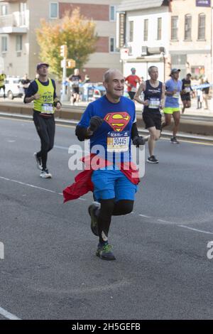 50 Jahre New York City Marathon Rennen im Jahr 2021 nach keinem Rennen im Jahr 2020 tun, um die Covid-19 Pandemie. Der ältere Mann läuft den Marathon mit seinem Superman-Trikot entlang der 4th Avenue durch das Park Slope-Viertel von Brooklyn. Stockfoto