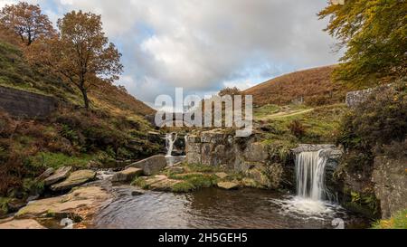 Zwei Wasserfälle, die in den hübschen Herbstfarben bei Three Shires Head eingefangen wurden, wo sich die Grafschaften Staffordshire, Cheshire und Derbyshire treffen. Stockfoto