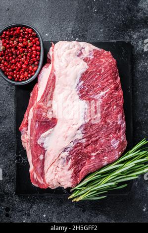 Außen roh Rundes Rinderbraten auf Marmorplatte geschnitten. Schwarzer Hintergrund. Draufsicht Stockfoto