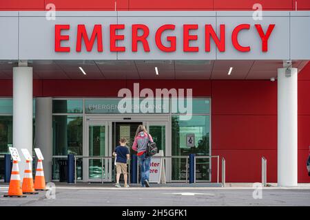 Frau und Kind betreten die Notaufnahme des Northside Hospital Gwinnet in Lawrenceville (Metro Atlanta), Georgia. (USA) Stockfoto