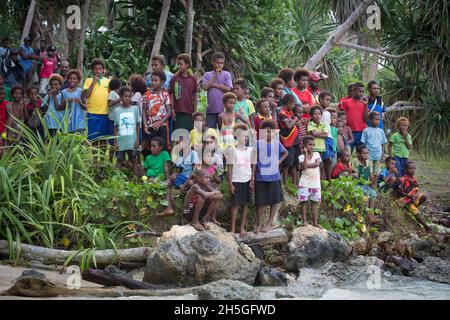 Kinder versammelten sich am Ufer der Tuam-Insel Siassi, Papua-Neuguinea; Tuam-Insel, Siassi-Inseln, Papua-Neuguinea Stockfoto