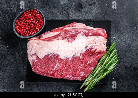 Außen roh Rundes Rinderbraten auf Marmorplatte geschnitten. Schwarzer Hintergrund. Draufsicht Stockfoto