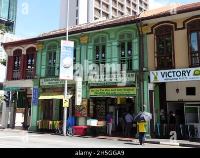 Alte Geschäftshäuser an der North Bridge Road gegenüber der Sultan Moschee mit Restaurants, die indische muslimische Küche verkaufen, und modernen Gebäuden im Hintergrund. Stockfoto