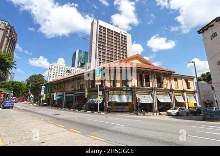 Alte Geschäftshäuser an der North Bridge Road gegenüber der Sultan Moschee mit Restaurants, die indische muslimische Küche verkaufen, und modernen Gebäuden im Hintergrund. Stockfoto