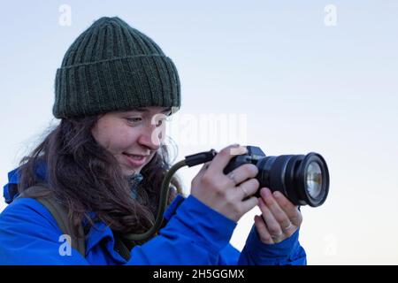 Junge Frau, die mit Digitalkamera und Objektiv im Whytecliff Park, Horseshoe Bay, British Columbia, Kanada, die Natur fotografiert Stockfoto