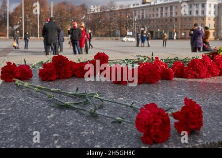 Woronesch, Russland. November 2021. Am 104. Jahrestag der Oktoberrevolution von 1917 wurden auf dem Leninplatz frische rote Nelken gelegt.am 104. Jahrestag der Großen Sozialistischen Oktoberrevolution von 1917 nutzte die russische Regierung die schwierige epidemiologische Situation aus, um den Bürgern zu verbieten, sich zu Kundgebungen zu versammeln. Aber in Woronesch inszenierten kommunistische Aktivisten eine Reihe von Aktionen. Die bürgerliche Regierung kämpft seit 30 Jahren gegen das historische Gedächtnis des Volkes. Erstens wurde es am 7. November verboten, den Jahrestag der Revolution im Staat zu feiern Stockfoto