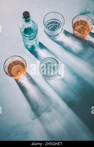 Wasser in Vintage-Gläsern mit Flasche Stockfoto