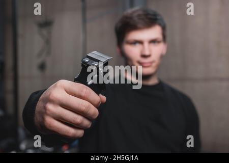 Ein Typ hält eine elektrische Rasiermaschine. Friseursalon. Stockfoto