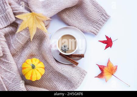 Heißer Kaffee mit Sternanise und Zimt in einer Tasse, gelbem Kürbis und Herbstblättern. Draufsicht, flach liegend. Herbstkonzept Stockfoto