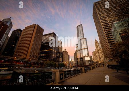 Blick am frühen Morgen auf den Riverwalk neben dem Hauptstiel des Chicago River mit Wolkenkratzern im Hintergrund, Downtown Chicago, IL, USA Stockfoto