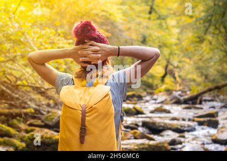 Junge Wanderin, die in einem fließenden Fluss in Passerelle d'Holzarte in Larrau, Frankreich, auf Felsen läuft Stockfoto