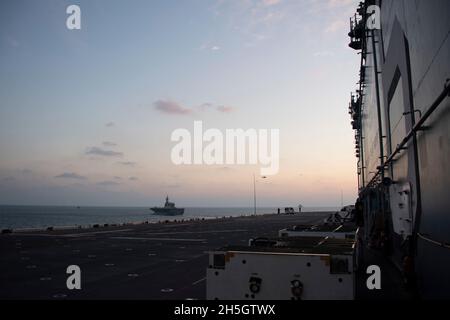 OSTCHINESISCHES MEER (NOV 3, 2021) das nach vorne eingesetzte amphibische Sturmschiff USS America (LHA 6) segelt in Formation mit dem Schiff der japanischen Maritime Self-Defense Force JS Ise (DDH 182). Amerika, das führende Schiff der America Amphibious Ready Group, ist im Verantwortungsbereich der 7. Flotte der USA tätig, um die Interoperabilität mit Verbündeten und Partnern zu verbessern und als einsatzbereite Einsatztruppe für den Frieden und die Stabilität in der Region Indo-Pazifik zu dienen. (USA Navy Foto von Mass Communication Specialist 2nd Class Jomark A. Almazan) Stockfoto