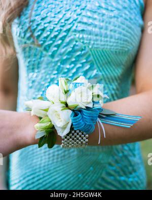 Frau in blauem Kleid mit blauer und weißer und grüner Corsage Stockfoto