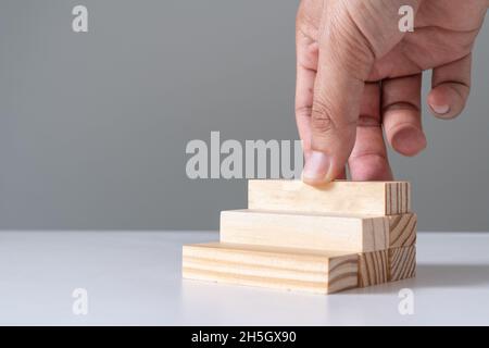 Holzblock, der von Hand als Treppenstufe stapelt, anordnen Stockfoto