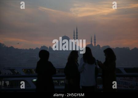 Istanbul, Türkei. November 2021. Menschen gesehen an der Galata-Brücke, mit der Suleymaniye-Moschee im Hintergrund während des Sonnenuntergangs. Kredit: SOPA Images Limited/Alamy Live Nachrichten Stockfoto