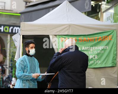 Paris, Frankreich. November 2021. Ein Bewohner spricht mit einem medizinischen Personal vor einem schnellen COVID-19-Testvorführzelt in Paris, Frankreich, am 9. November 2021. Der französische Präsident Emmanuel Macron kündigte am Dienstagabend an, die vorab beschlossene Lockerung der Anti-COVID-19-Maßnahmen zu verschieben, da Frankreich die fünfte Pandemiewelle durchläuft. Menschen über 65 Jahre alt und die gefährdetsten werden eine Auffrischungsdosis erhalten müssen, um ihren Gesundheitsausweis ab Dezember 15 zu validieren. Kredit: Gao Jing/Xinhua/Alamy Live Nachrichten Stockfoto