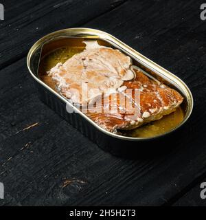 Wild Alaska Lachs Räucherfischset aus der Dose, auf schwarzem Holztisch-Hintergrund, mit Textraum und Platz für Text, quadratisches Format Stockfoto