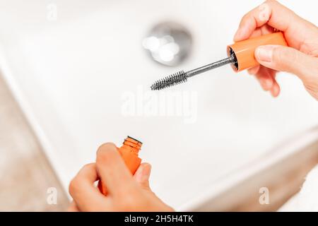 Hände einer Frau mit Wimpern-Bürste. Stockfoto